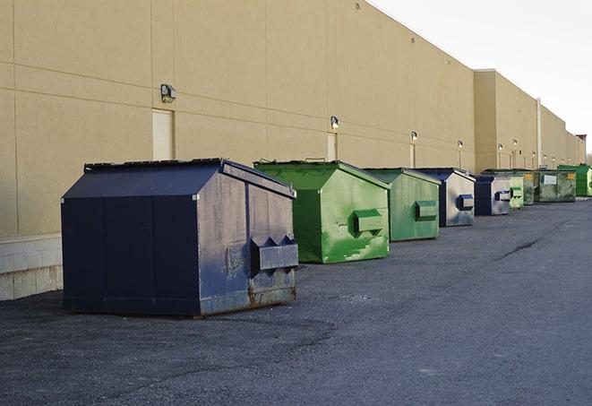 construction workers toss wood scraps into a dumpster in Gallup